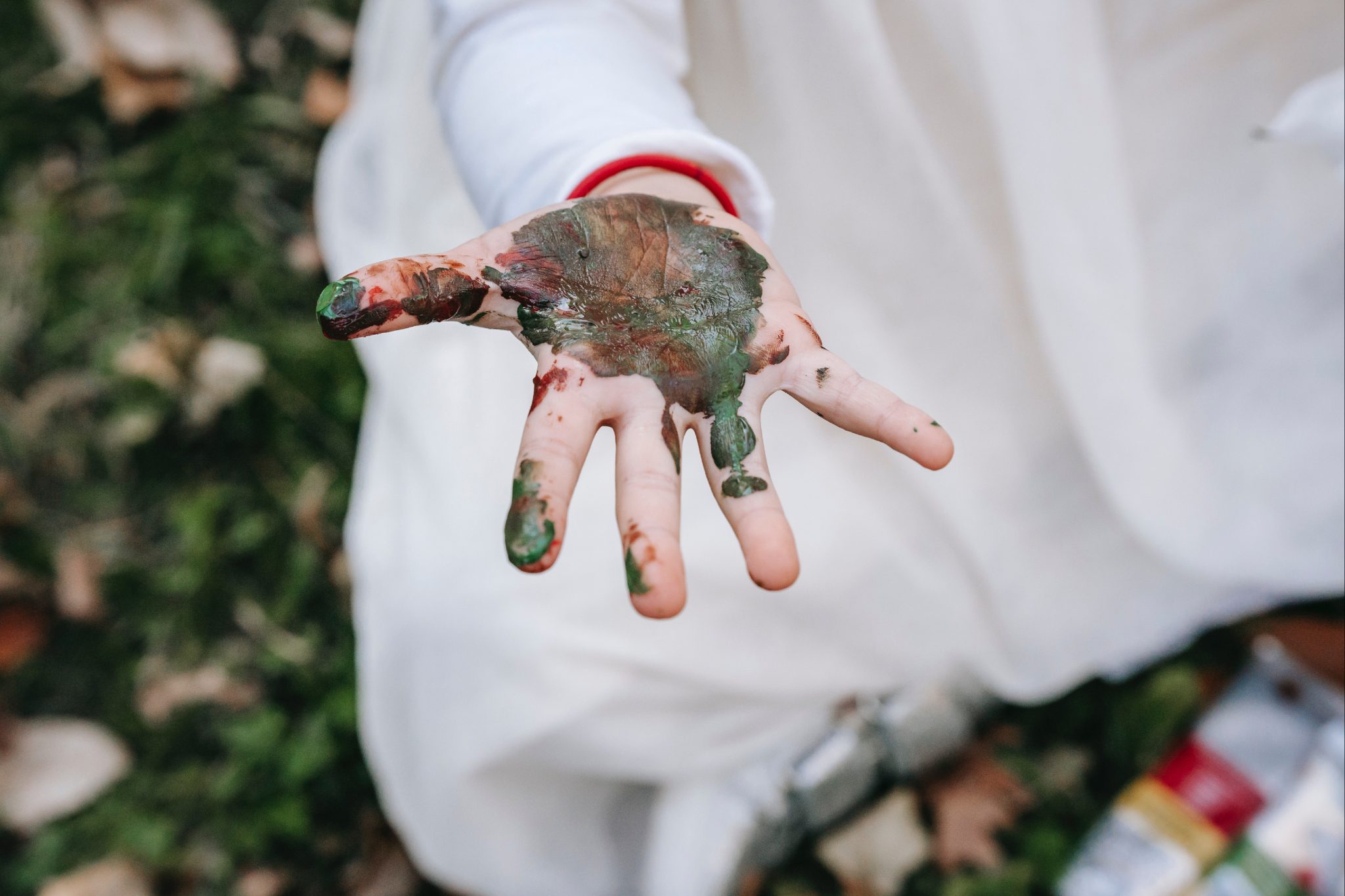 Child with their hand covered in paint