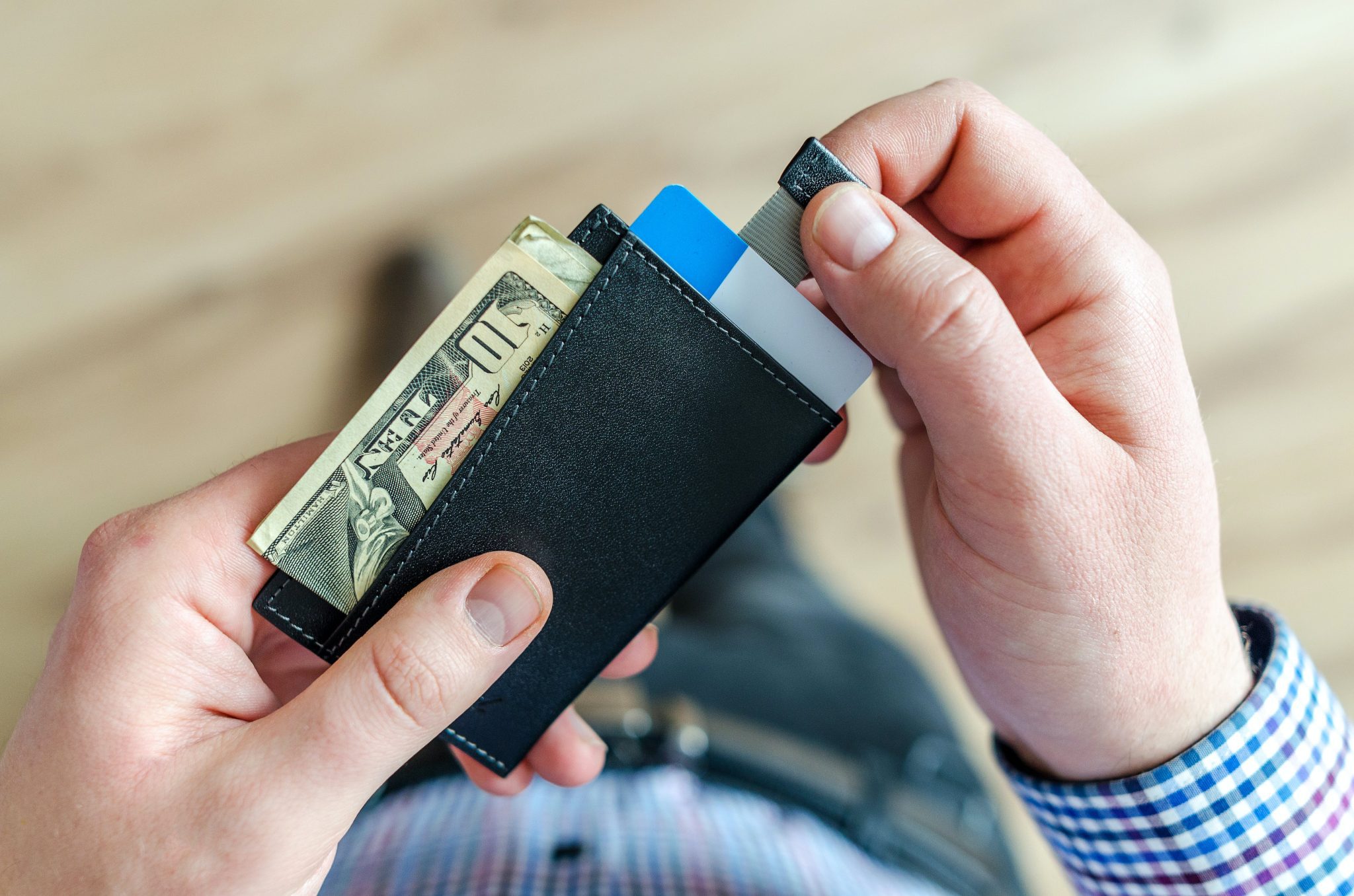 An image of male hands pulling a card from a wallet