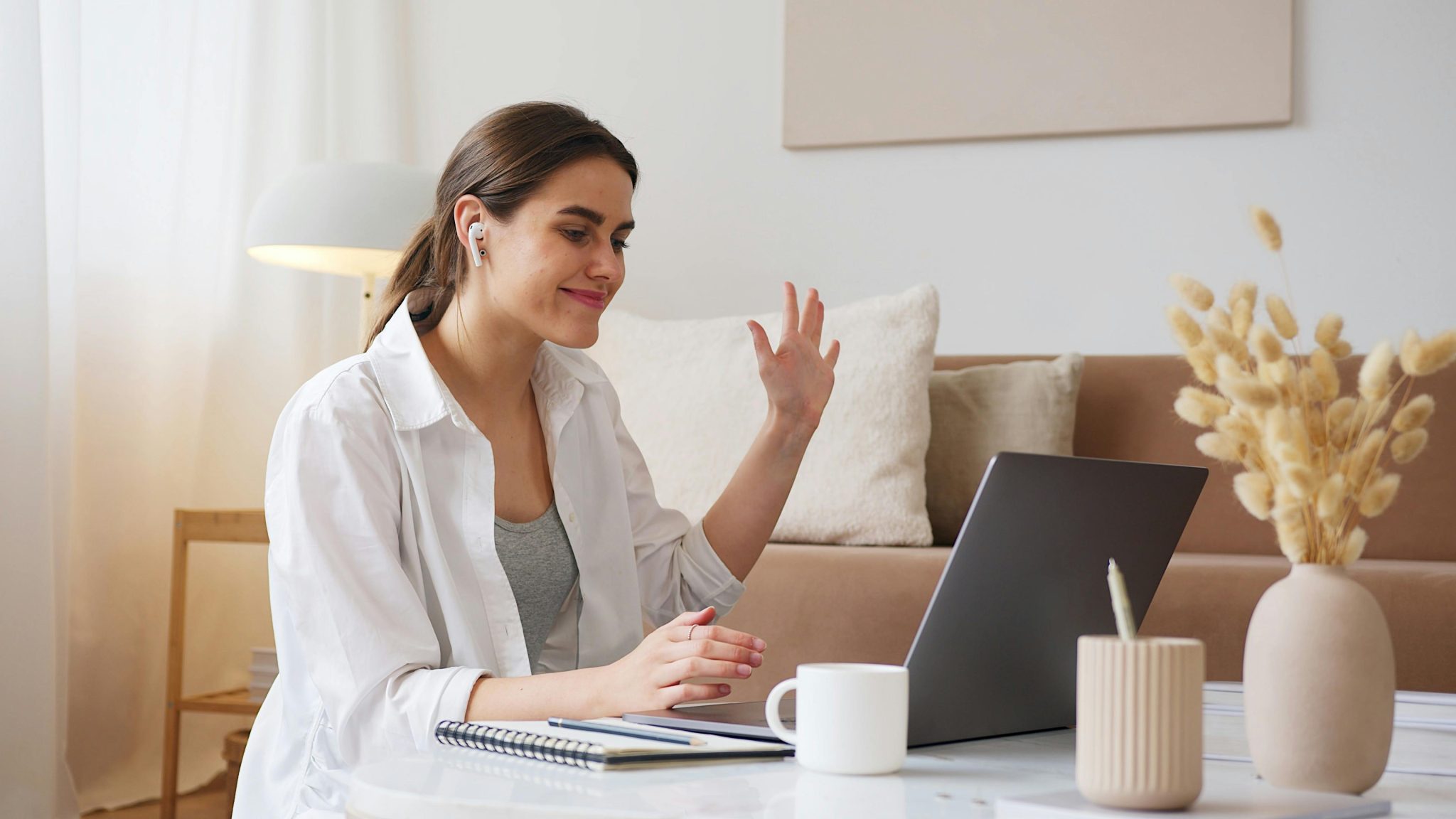 A woman waving to someone on a conference call