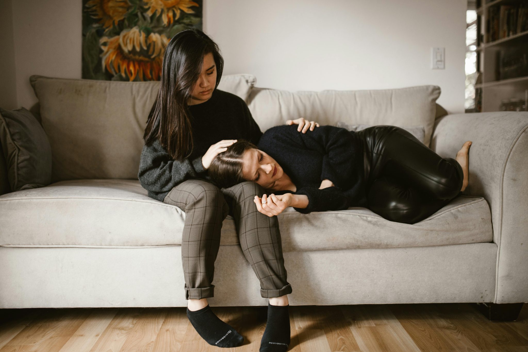 A woman comforting another woman who looks tired and sad